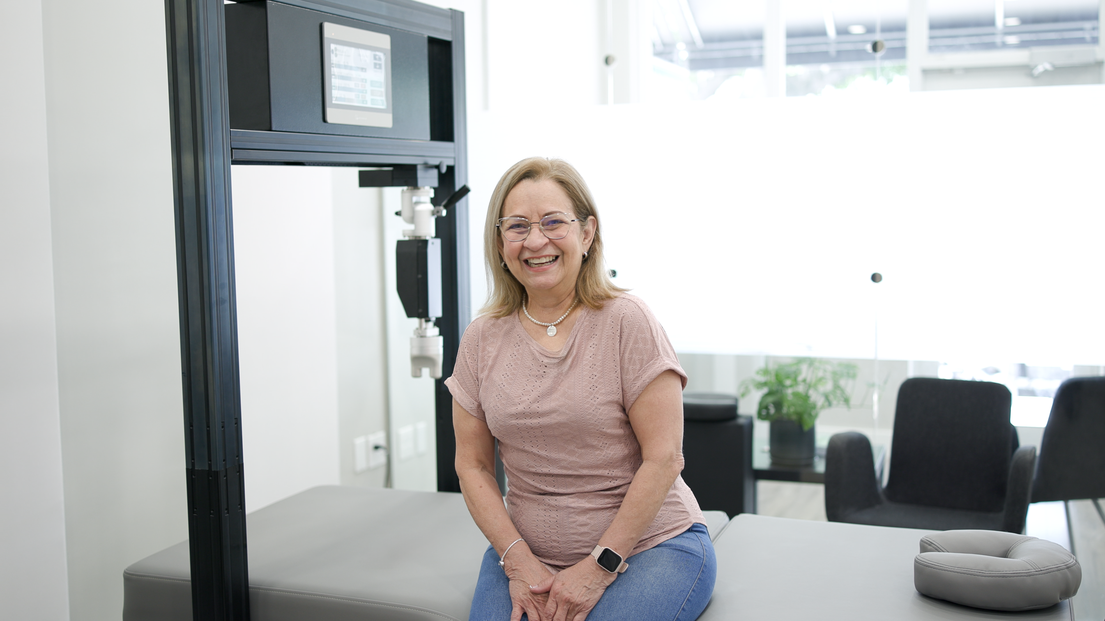 Smiling client at TheraMax with robotic therapy equipment
